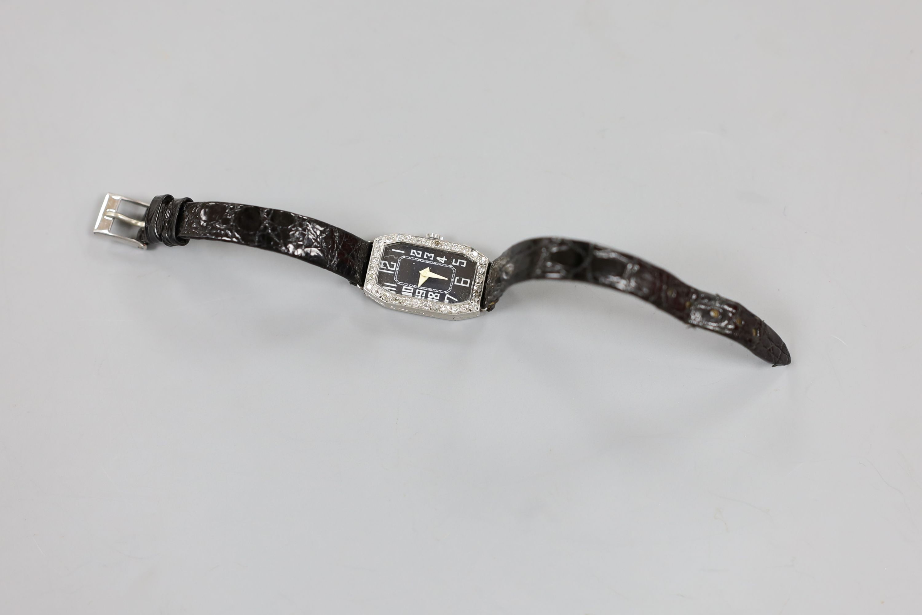 A lady's white metal (stamped platinum) and diamond set cocktail watch, on a leather strap, cased diameter 18mm, gross weight 15.8 grams.